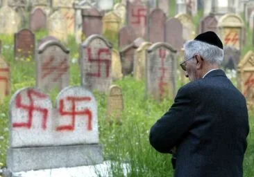 Žid na hřbitově pomalovaném hákovými kříži